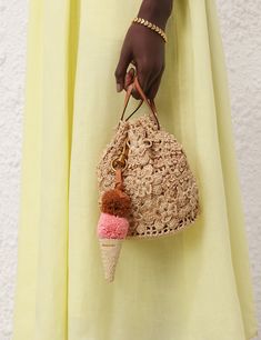 a woman is holding an ice cream cone purse