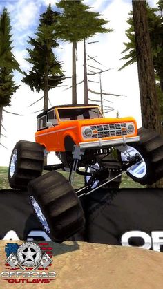 an orange truck is jumping over some black tires