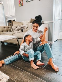 a woman sitting on the floor with her child