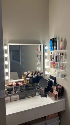 a vanity with lights and makeup on it