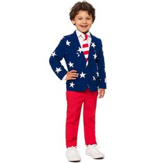 a young boy dressed in an american flag suit and tie, standing with his hands on his hips