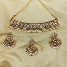 Add a touch of regal elegance to your bridal look with our Gold Plated Choker Necklace with Earrings and Maangtikka. This gorgeous jewelry set is designed to elevate your traditional Indian attire, featuring a beautifully crafted choker necklace with intricate gold plating. Paired with matching earrings and a complementary maangtikka, this set embodies the perfect blend of tradition and modern style, making it ideal for weddings, cultural events, or festive celebrations. Handcrafted with precision, the gold-plated choker sits comfortably around the neck, while the earrings and maangtikka complete the look with elegance. Whether you're a bride or attending a special event, this jewelry set adds a touch of sophistication and grace to your ensemble. The high-quality gold plating ensures long- Indian Jewelry Set, Kundan Choker Necklace, Regal Elegance, Kundan Jewellery Set, Kundan Choker, Indian Jewelry Sets, Choker Necklace Set, Cultural Events, Indian Attire