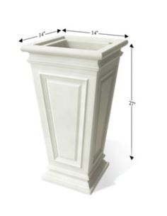 a tall white planter sitting on top of a white floor next to a ruler