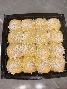 a tray filled with rolls covered in sesame seeds and sprinkled with white rice