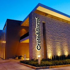 the entrance to an office building lit up at night with lights shining on it's side