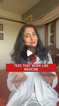 a woman sitting on top of a table in front of a red sign that says teas that work like medicine