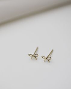 E&E PROJECT 14K SOLID GOLD SERIES ------------------------------------------------------ Tiny Ribbon Bow Earrings Lightest cute small bow earrings. Wear it while showering, swimming all day, everyday All earrings post and backings are 14K Gold 5mm tiny Star studs / 1 Pair with 14K gold backings --------------------------------------- ■ SHIPPING UPGRADES You can find shipping upgrades options in the drop bar menu when you check out. * Within the U.S Regular First-class : 2-6 business days Pri Preppy Stud Earrings, Small Gold Earrings, Simple Studs, Preppy Jewelry, Mini Bow, Casual Jewelry, Gold Ring Designs, Jewelry Accessories Ideas