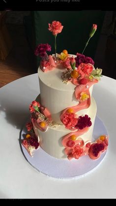 a three tiered white cake with flowers on top