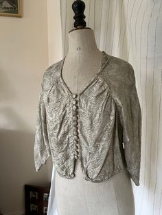 Gorgeous vintage 1930s 1940s metallic blouse. Silver (with subtle golden shimmer depending on the light) lamé floral print fabric. Sweetheart neckline, 13 fabric-covered buttons down the front, 1 hook-and-eye closure at bottom front center, batwing sleeves, three-quarter length sleeves with beautiful tulip shape detail at cuffs.   Such a cool statement blouse! Perfect for your next night out on the town or party! And of course for the Holiday Season and New Year's Eve !   Very versatile: looks v Vintage Gold Silk Top, Vintage Party Blouse With Buttons, Statement Blouse, Metallic Blouses, Womens Blouses, Floral Print Fabric, Antique Clothing, Fabric Covered Button, Black Trousers