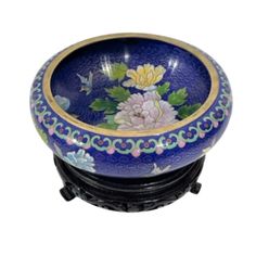 a blue bowl with flowers and butterflies on it