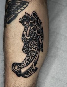 a man's leg with a tattoo on it that has an image of a woman holding