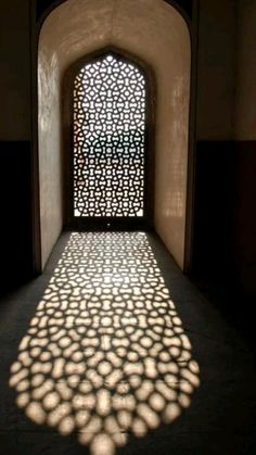 shadows cast on the wall and floor in an archway