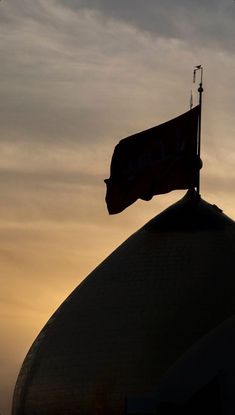 a flag flying on top of a building with a sky in the backround