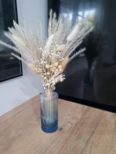 a vase filled with white flowers on top of a wooden table