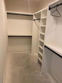 an empty walk in closet with white walls and open shelving units on either side