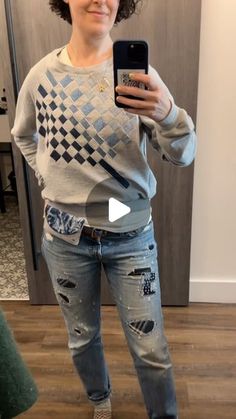 a woman is taking a selfie in the mirror with her cell phone and wearing ripped jeans