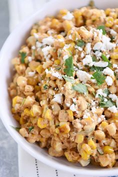 a white bowl filled with corn and feta cheese