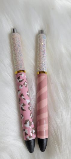 two pink and black umbrellas sitting on top of a white fur covered floor