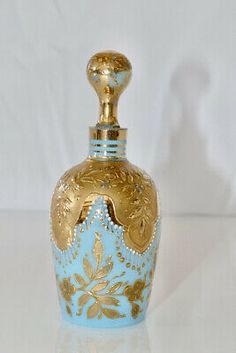 a blue and gold vase sitting on top of a white table