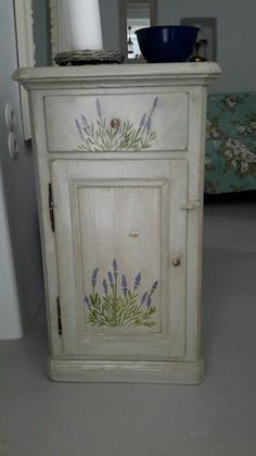 an old white cabinet with painted flowers on it