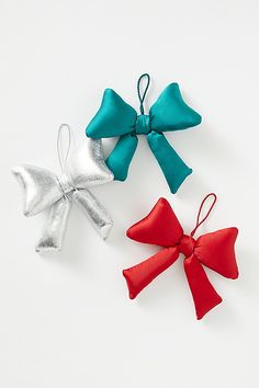 three different colored bows are on a white surface with one red, one blue and one silver