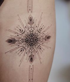 a woman's thigh with an intricate tattoo design on the side, and arrows coming out of it