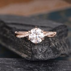 a close up of a diamond ring on a rock