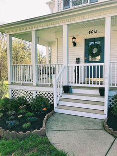 the front porch of a white house with steps leading up to it's door