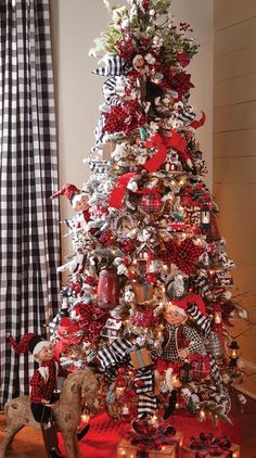 a christmas tree decorated with red, white and black ribbons