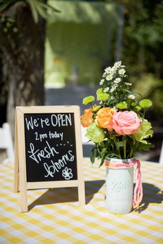 a vase filled with flowers sitting on top of a yellow and white checkered table cloth