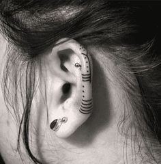 a woman's ear is decorated with black and white designs