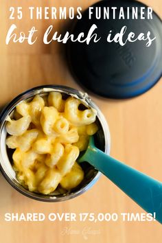 a cup filled with macaroni and cheese on top of a wooden table