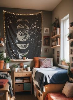 a dorm room with a bed, desk and hanging tapestry