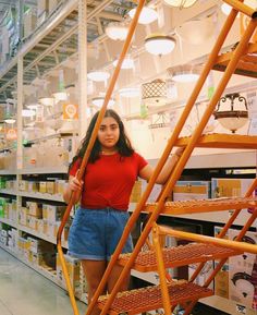 a woman standing next to a ladder in a store