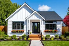 a white house with flowers in the window boxes and steps leading to the front door