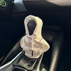 a white hoodie sitting on top of a steering wheel in the center console of a car