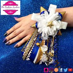 a woman's hand with blue and gold nail polish holding a bouquet of bracelets