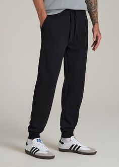 Relax In Style The Ultimate Extra-Long Men's Joggers Ready to meet your new favorite joggers? Our Wearever 2.0 Fleece Tall Men's Joggers are here to revolutionize your chill time. Designed for men over 6', these aren't just any joggers—they're your go-to for year-round comfort. Made from cozy fleece with a stretch fabric that moves with you, they offer a modern fit that's just right, not too tight. The updated trim, stylish drawstring, and thoughtful branding elevate these from basic to essentia Black Tapered Leg Activewear For Jogging, Black Joggers With Ribbed Waistband And Tapered Leg, Black Tapered Joggers With Ribbed Waistband, Black Tapered Leg Joggers With Ribbed Waistband, Black Tapered Leg Joggers Athleisure, Black Tapered Leg Joggers For Athleisure, Black Tapered Leg Sweatpants For Gym, Black Sports Joggers With Tapered Leg, Black Joggers With Comfort Waistband For Jogging