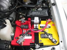 the engine compartment of a car with two batteries and wires connected to it's terminals