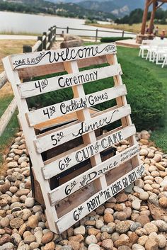 a wooden sign sitting on top of a pile of rocks