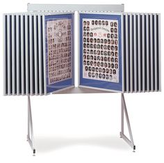 an open book with pictures on it and two metal legs in front of white background