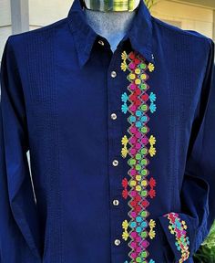 a man's blue shirt with multicolored flowers on the front and chest