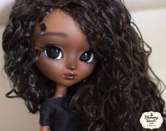 a close up of a doll with curly hair