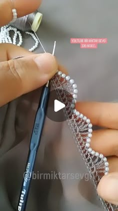 someone is working on something with beading