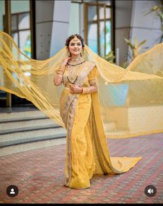 a woman in a yellow sari standing outside