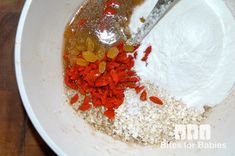 the ingredients are being mixed together in a white bowl on top of a wooden table