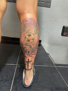 a person with a tattoo on their leg and cross in the middle of his leg