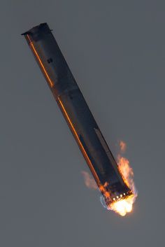 a rocket that is flying through the air with fire coming out of it's side