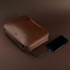 an electronic device is plugged in to a brown case on the table next to it