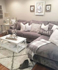 a living room filled with furniture and pillows on top of a white rug in front of a gray couch